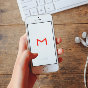 Hand holding smartphone checking gmail.
