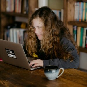 woman in black jacket using macbook pro